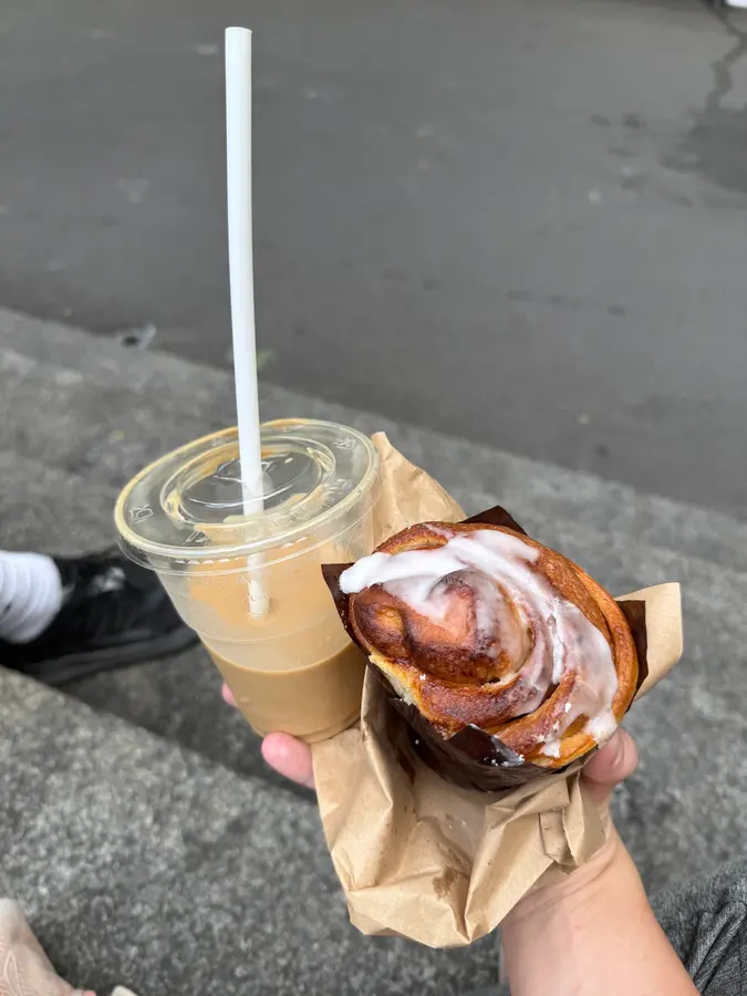 Zimtrolle mit Zuckerguss und ein Iced Latte zum Mitnehmen